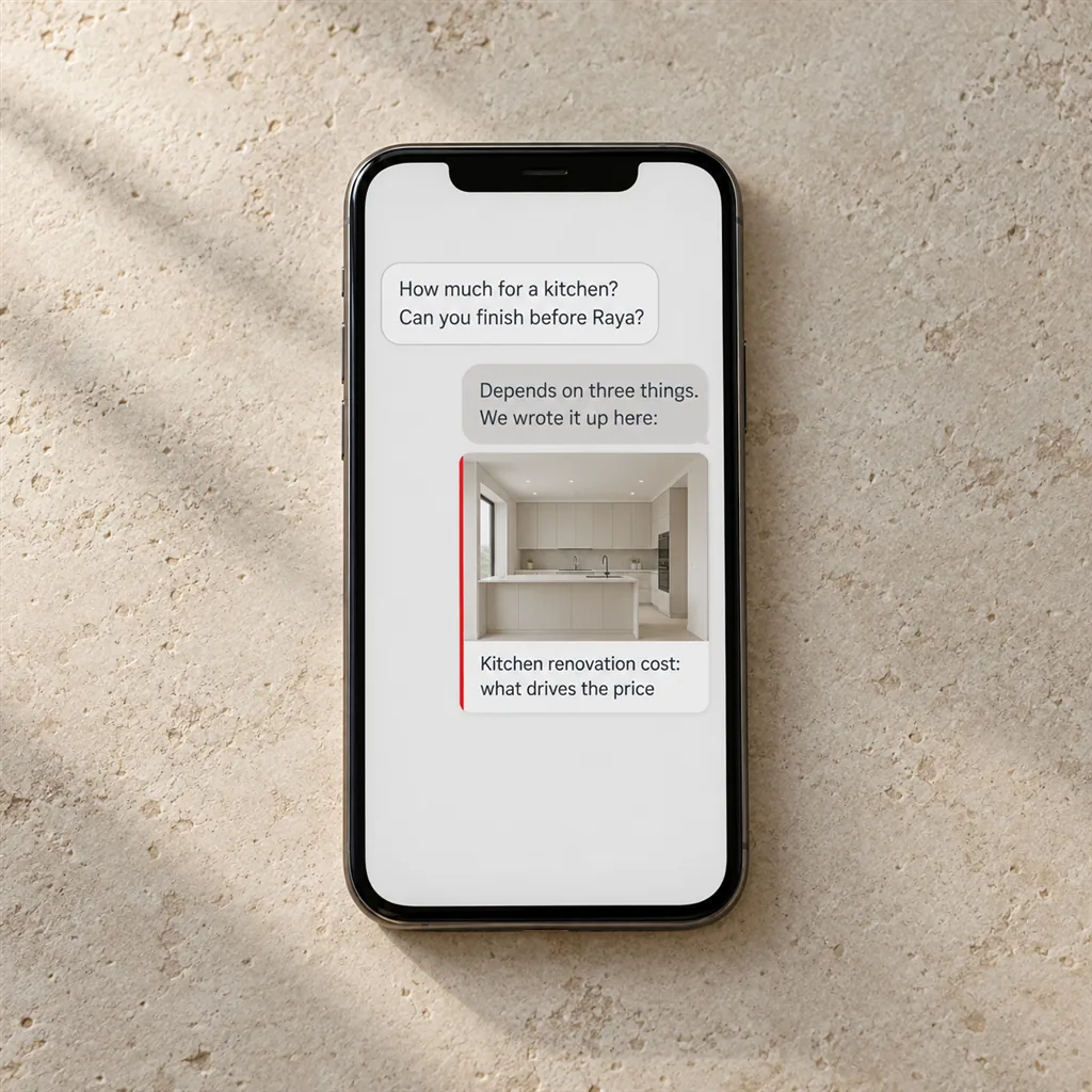 A smartphone lying on a stone tabletop showing a messaging chat in which a customer asks How much for a kitchen? Can you finish before Raya?, and the business replies Depends on three things. We wrote it up here: with a link card showing a photo of a pale modern kitchen and the title Kitchen renovation cost: what drives the price, edged in scarlet